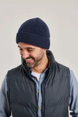 Gorro de punto color azul marino, tejido con punto acanalado y borde doblado.