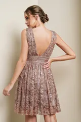 Vestido corto de fiesta con escote en V profundo, sin mangas y falda con vuelo. Está confeccionado en una base de tul con bordados florales y aplicaciones de lentejuelas y glitter en tonos rosados y dorados.