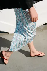 Sandalias destalonadas de cuero, tipo ojota con taco cuña negro y tira delantera en color bordó.