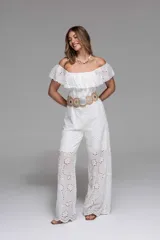 Mono largo blanco de broderie con escote off-shoulder con volados y cinturón marrón con hebilla circular.