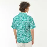 Camisa de manga corta con cuello cubano y estampado de hojas abstractas en blanco sobre fondo verde.
