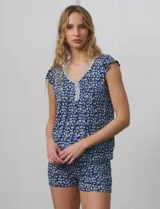 Conjunto de pijama marca René Rofé, compuesto por un short con cintura elastizada y una remera de escote en V con aplique de puntilla, botones y detalle plisado.