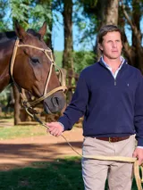 Buzo de tejido punto panal, color azul marino, con cuello alto y cierre frontal parcial.