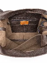 Cartera de cuero graneado marrón, de diseño amplio y desestructurado, con asas cortas para mano y correa larga regulable para hombro.