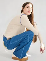 Polera de manga larga confeccionada en tela rib color bordó, con cuello alto y hombreras. Presenta costuras a la vista con pespuntes en hilo de color contrastante en el cuello, puños, hombros y ruedo.