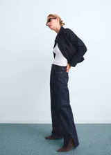 Jeans de corte recto y tiro medio, confeccionados en tejido de algodón estilo vaquero en tono azul oscuro. Presentan diseño de cinco bolsillos, cierre de botón con cremallera, trabillas para cinturón y aberturas laterales en el bajo.