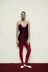 Vestido corto color rojo oscuro (vino) con escote en V pronunciado y tirantes finos. Presenta un diseño con flecos o tiras superpuestas que caen verticalmente y terminación en encaje festoneado en el ruedo y el escote.