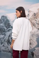 Buzo oversize de tejido de punto con textura acanalada, color blanco, de cuello redondo, manga larga y tajos laterales en el ruedo.