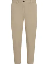 Pantalón chino color beige de corte slim, con cierre de botón y cremallera, cuatro bolsillos y logo de Tommy Hilfiger bordado en el bolsillo trasero.