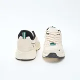 Zapatillas deportivas de estilo urbano confeccionadas en malla y material sintético. Presentan una combinación de colores en crema, negro y verde, con suela robusta y diseño ergonómico.