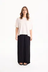 Blusa de lino color crudo, de manga corta con detalles de volados en las mangas y en el ruedo.