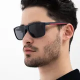 Lentes de sol INVU con montura rectangular color azul marino y patillas rojas. Lentes polarizados grises.