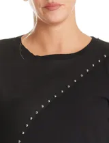Buzo de cuello redondo y manga larga, con diseño combinado en el frente que integra una sección de tejido de punto y otra de material tipo gamuza o eco cuero, decorado con una línea diagonal de tachas metálicas.