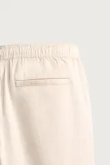 Pantalón de corte regular fit confeccionado en tejido mezcla de algodón, con cintura elástica ajustable mediante cordón, bolsillos laterales y bolsillos traseros de vivo.