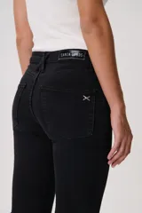 Jean oxford tiro bajo, color negro, de corte ajustado en la parte superior y con botamanga acampanada. Cuenta con bolsillos funcionales, pasacintos y cierre frontal con botón metálico.