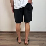 Short de algodón rústico con corte holgado y ruedo desflecado.