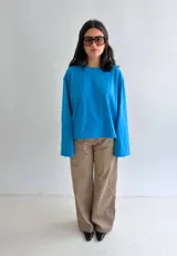 Remera oversize de manga larga y ancha, color celeste, confeccionada en algodón con cuello redondo.