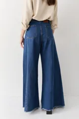 Pantalón de jean azul de tiro alto y corte wide leg súper amplio, con diseño de perneras ancha y terminación desmechada en el ruedo.