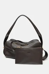 Bolso alargado de piel color marrón oscuro, con asa de hombro y cierre de cremallera. Incluye cartera con bolsillo extraíble.