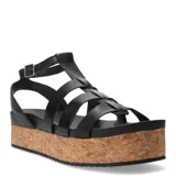 Sandalias tipo franciscanas de cuero negro con plataforma de corcho y suela dentada. Presentan tiras entrecruzadas y cierre con hebilla metálica en el tobillo.