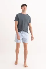 Short de baño color celeste, con cintura elástica, cordón ajustable y corte corto.