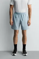 Pantalones deportivos cortos de tejido técnico ligero y elástico, con cintura elástica ajustable, bolsillos frontales y aberturas laterales en el bajo.