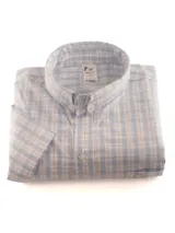 Camisa celeste a cuadros blancos, de manga corta, con cuello abotonado y bolsillo en el pecho con logo bordado.