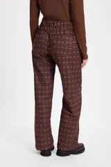 Pantalon de pierna recta con estampado tipo patchwork en tonos azul, bordó y blanco. Cuenta con cintura ajustable con elástico y cordón, dos bolsillos laterales redondeados y dos bolsillos traseros tipo plaqué.