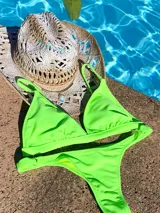 Top de bikini verde neón, de corte triangular fijo, con copas desmontables, breteles regulables y broche trasero con tres niveles de ajuste.