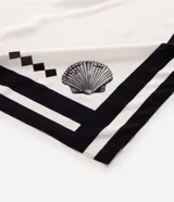 Pareo de playa rectangular confeccionado en viscosa liviana de color blanco, con estampado de caracolas marinas y detalles gráficos en negro en los bordes.