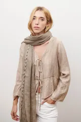 Chaqueta ligera de manga larga en color azul, con escote en V y cierre frontal mediante dos lazos ajustables. Presenta un diseño fluido con textura sutil y corte recto.