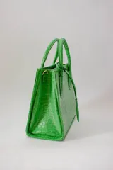 Cartera mediana de cuero blanco, con asa fija y correa regulable desmontable.