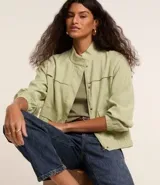 Campera bomber negra de viscosa con cierre delantero, bolsillos con solapa y pespuntes contrastantes en color blanco.