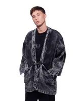 Kimono negro con efecto lavado, confeccionado en algodón. Tiene corte amplio, mangas 3/4, bolsillos laterales y cierre frontal con hebilla metálica.