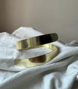 Brazalete dorado de metal con forma de espiral grueso.