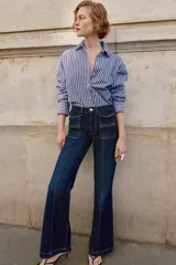 Camisa de corte clásico con cuello solapa y manga larga, confeccionada en tejido oxford con diseño de rayas verticales en azul y bordó. Presenta cierre frontal con botones y bajo con aberturas laterales.