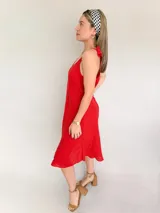 Vestido blanco de lino con breteles finos que se atan en los hombros.