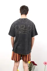 Remera de algodón con efecto lavado, cuello redondo y mangas cortas. Presenta un pequeño logo estampado en el pecho y una estampa de mayor tamaño en la espalda.