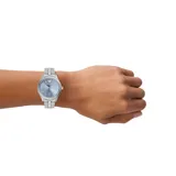 Reloj analógico Emporio Armani modelo Dario con caja de acero inoxidable de 42 mm, esfera azul con acabado sunray, indicadores de hora en relieve y ventana de fecha a las 6 en punto. Presenta una malla de eslabones de acero inoxidable en tono plateado.
