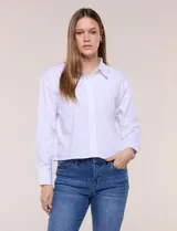 Camisa blanca estilo crop de la marca Zac & Rachel, confeccionada en mezcla de algodón. Presenta cuello con solapa, cierre frontal con botones, manga larga con puño ancho abotonado y diseño de corte corto.