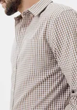 Camisa de manga larga con cierre frontal de botones, cuello clásico y bolsillo en el pecho. Presenta un diseño de rayas verticales finas en tonos azul y blanco.