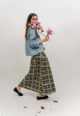 Falda midi de popelina de algodón negra con estampado geométrico de cuadros en tonos blancos, amarillos y rosados, con bolsillos laterales.
