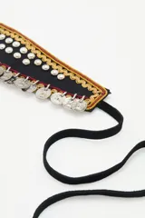 Cinturón tipo faja con base de cuero sintético color marrón, decorado con monedas plateadas y flor de tela negra.