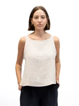 Musculosa de lino color beige con escote redondo y laterales abiertos unidos por tres lazos cosidos.