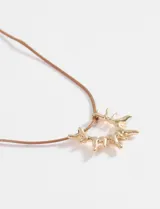 Collar largo de cordón fino color marrón con dije metálico plateado en forma de sol.