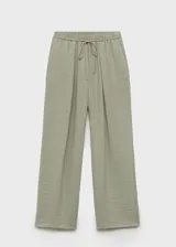 Pantalón largo de tiro alto color verde, con cintura elástica y cordón ajustable, de diseño recto y tejido con textura.