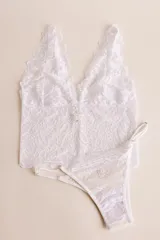 Topcito tipo bralette de encaje negro con escote en V profundo y tirantes anchos. El encaje es elastizado para un ajuste cómodo.