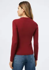 Camiseta de manga larga en tela acanalada color bordó, con cuello redondo y ajuste al cuerpo.