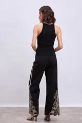 Musculosa de tejido de punto acanalado, color negro, con cuello halter y ajuste al cuerpo.