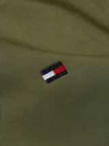 Campera bomber verde militar de Tommy Hilfiger con cierre frontal, cuello, puños y bajo acanalados. Tiene dos bolsillos laterales con botón a presión y logo de la marca bordado en el pecho.